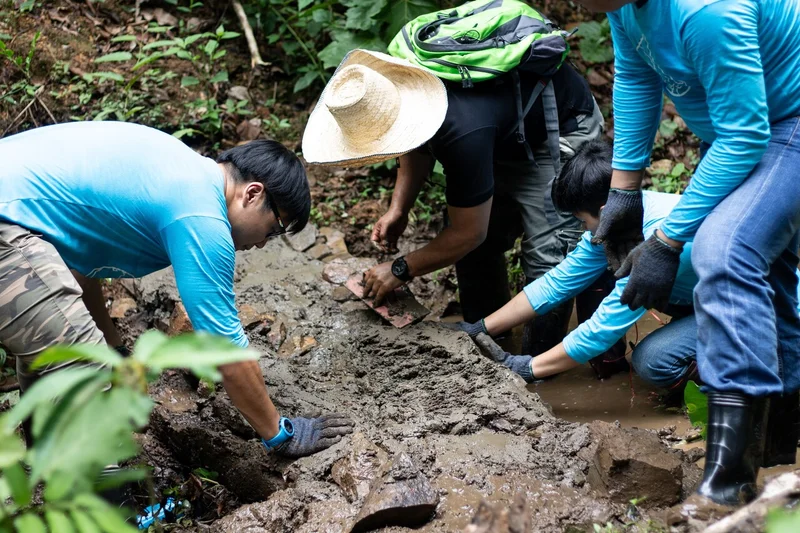 タイ北部・ピン川での、泥水をせき止める小型堰づくりの様子。ほかにも、小川の流れを緩やかにして土砂による浸食を防止したり、小川に土が流出するとこを防ぐための植樹など水源保全活動に取り組んでいます。