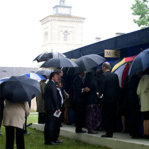 受付開始と呼応するように降り出した雨のため、受付を待つ人も傘を片手に。