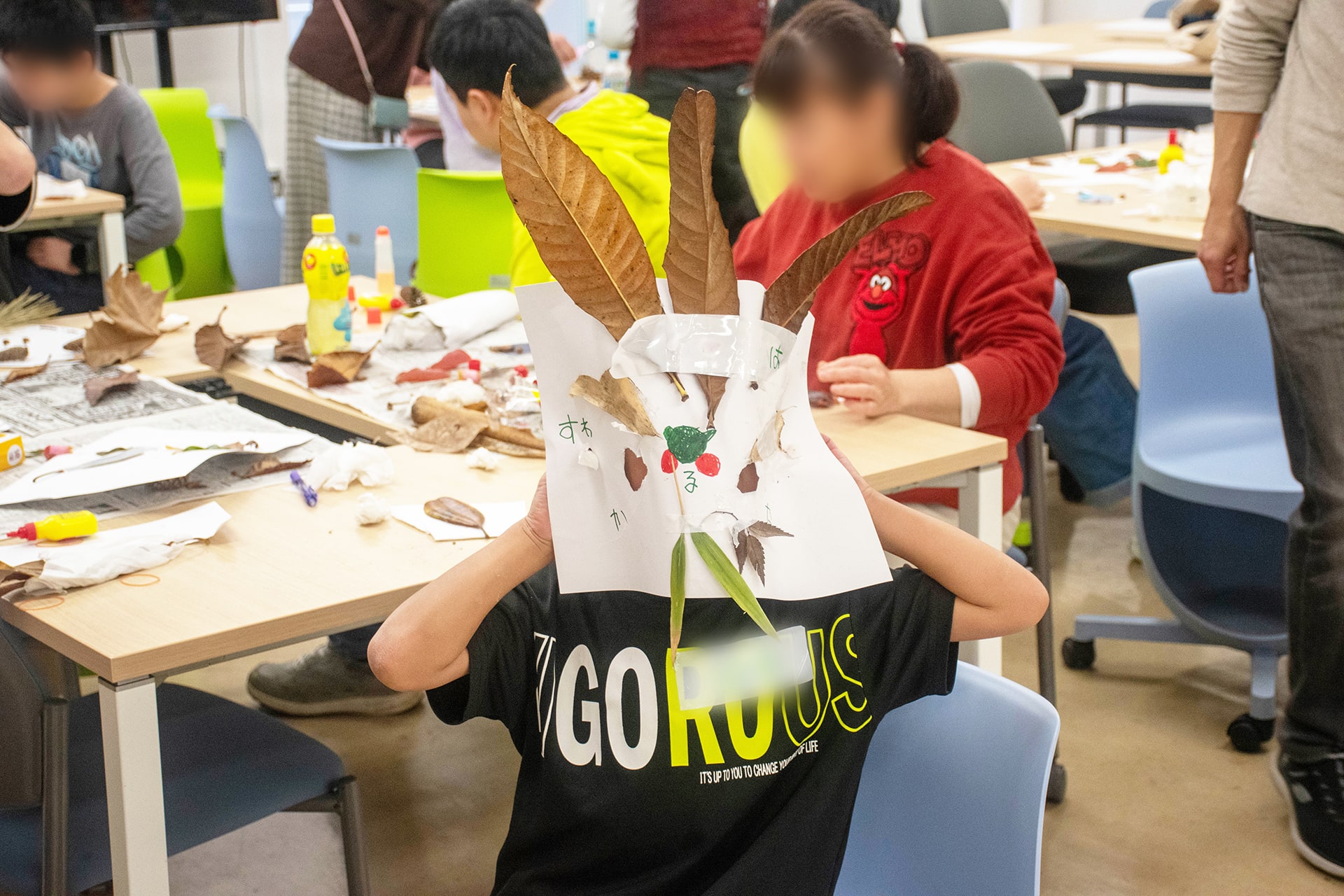 できあがったお面をつける子どもの参加者