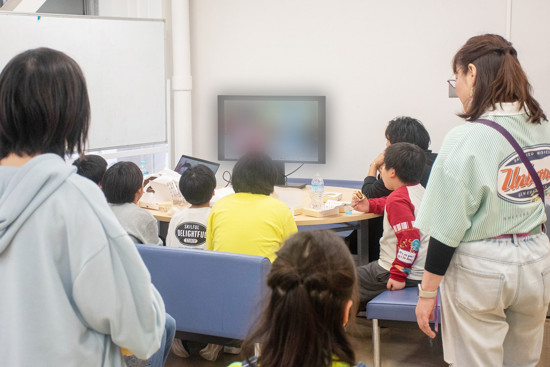 ワークショップ後、テレビを見ながら軽食を食べる子どもたち