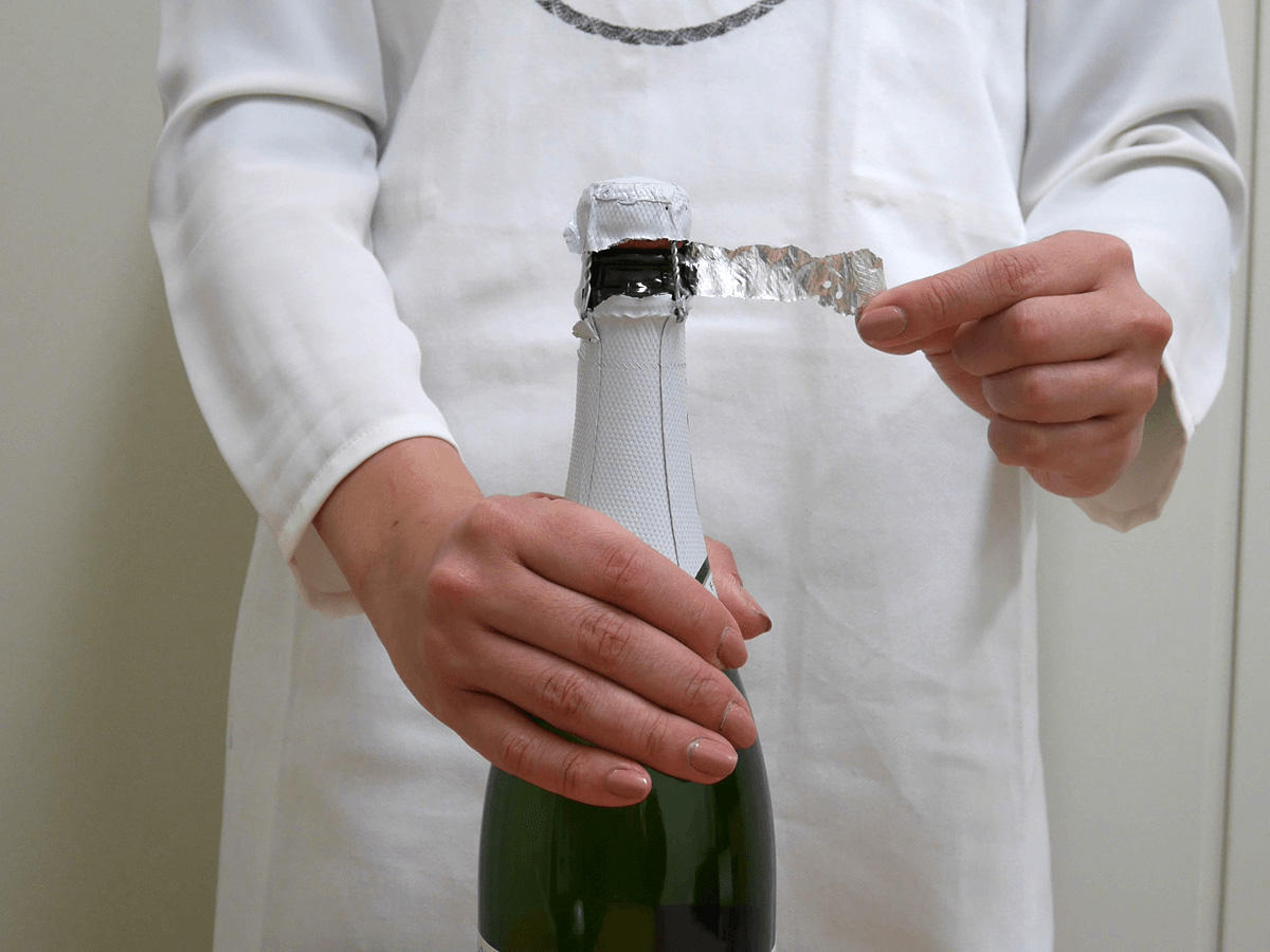 シャンパン、スパークリングワインの開け方解説の写真１。栓を覆っているシールをはがす。