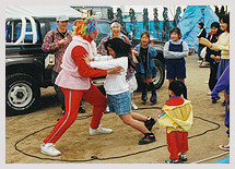 赤鬼に扮した劇団員と相撲をとる子どもたち（1995年3月神戸市長田区南駒栄公園）
