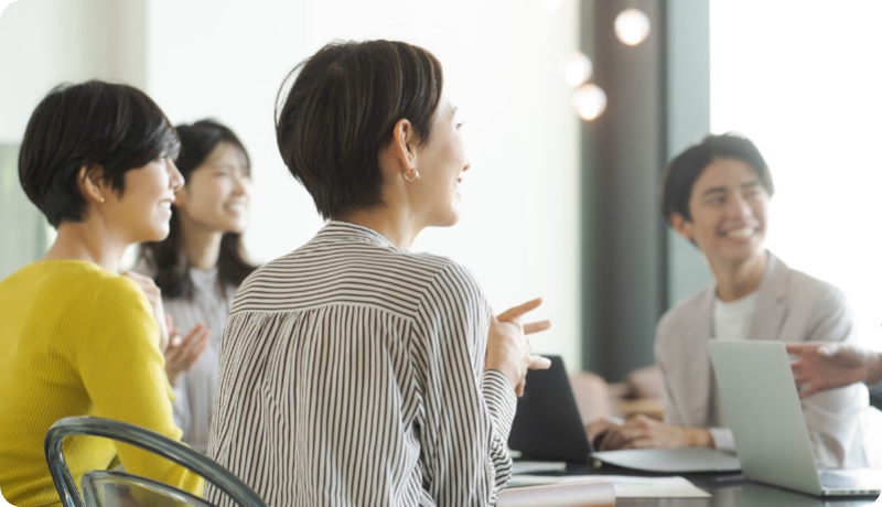 笑顔で会議を行う社員たち。活発な社内コミュニケーションが生まれている様子