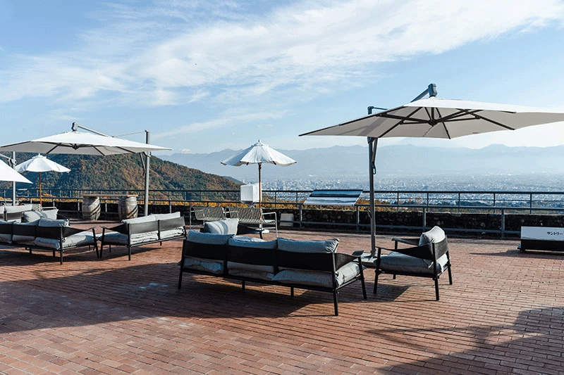 目の前に甲府盆地が広がるワイナリーの「富士見テラス」。標高500mの澄んだ空気のなか、甲斐駒ヶ岳、八ヶ岳、そして富士山が見わたせます。この雄大な自然が良質なぶどうを育てるのです。生産地を気軽に訪ねられるのも、日本ワインならではの魅力です。